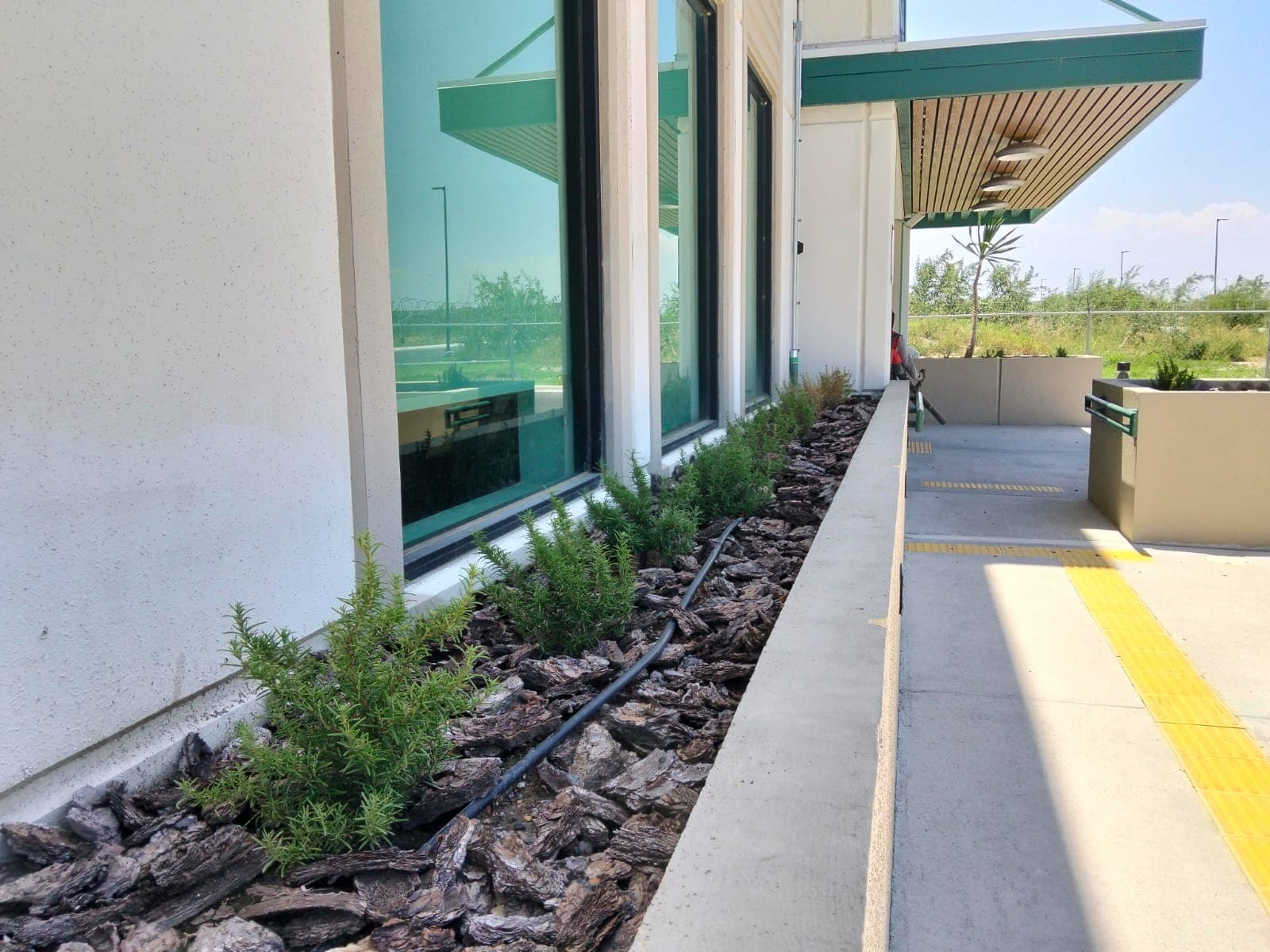 Instalación de acolchado (mulch) en fachada corporativa